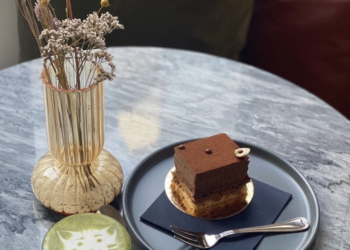 Marmortisch mit Schokoladentörtchen, Matcha Latte und Trockenblumen
