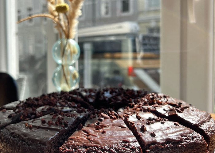Angeschnittener veganer Schokokuchen am Fenster