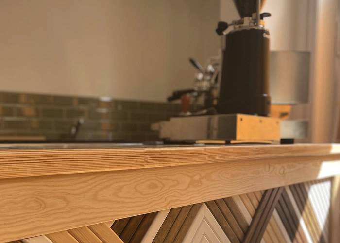 Bar mit Espressomaschine und hellem Holztresen