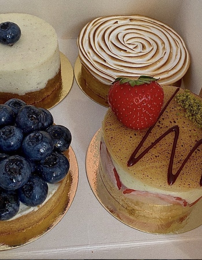 Vier French-Patisserie-Törtchen mit Beeren und Baiser