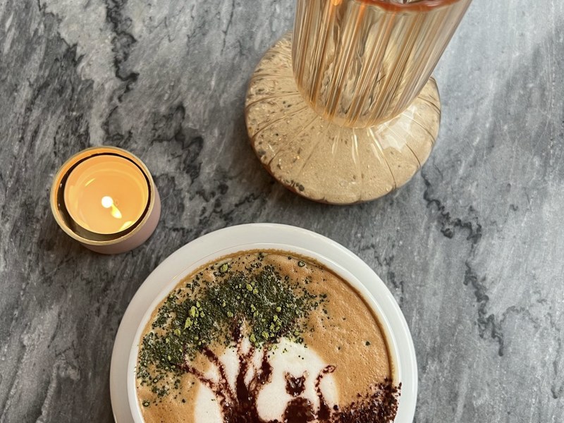 Cappuccino mit Baum-Latte-Art und Matcha-Pulver